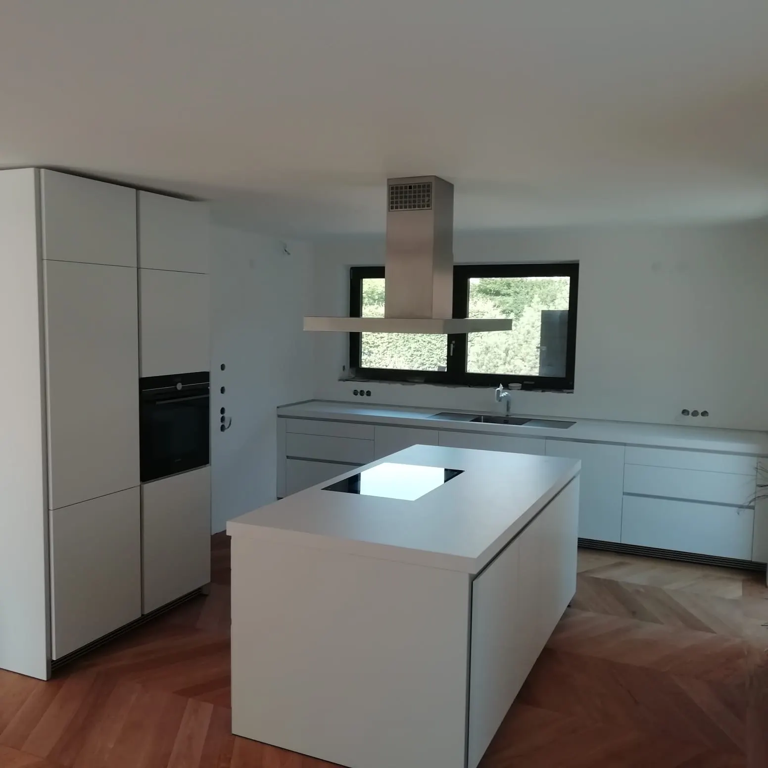 Weiße Kochinsel mit Kochfeld und Dunstabzugshaube