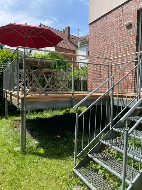 Holzterrasse mit Wendeltreppe in den Garten