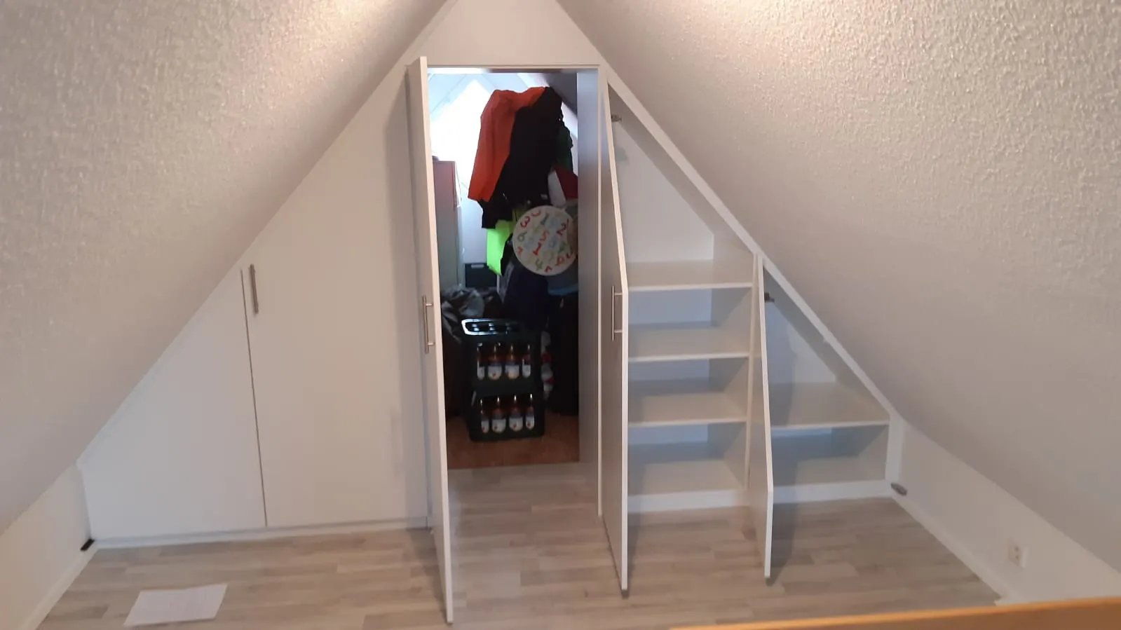 Begehbarer Drempel-Stauraum hinter Türen in der Dachschräge