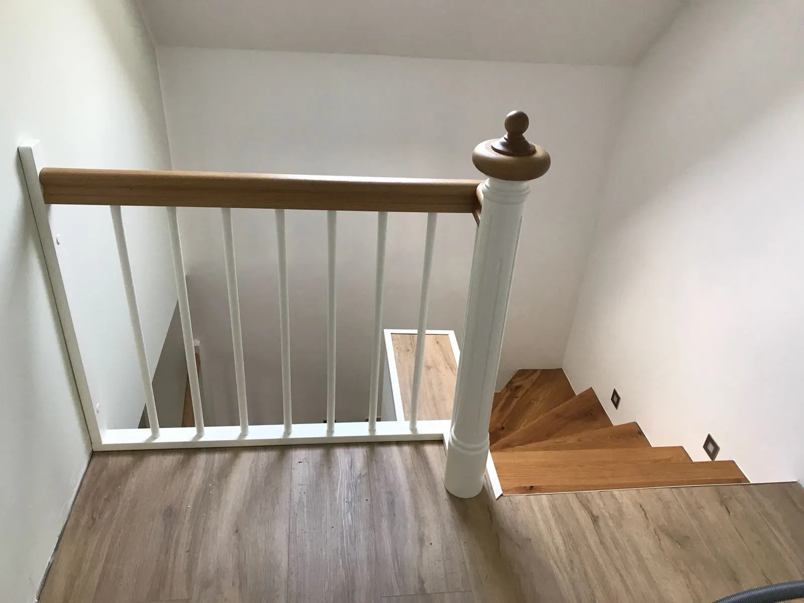 Treppe mit weißem Geländer und griffigem Handlauf aus Holz